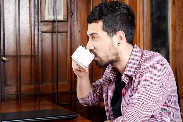 Młody człowiek Łacińskiej picia kawy w kawiarni. — Zdjęcie stockowe