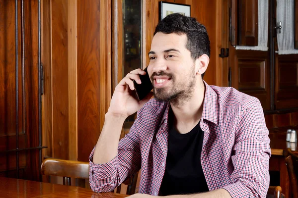 Łacińska człowiek rozmawia przez telefon w kawiarni — Zdjęcie stockowe