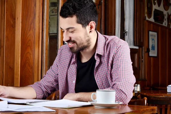 Latijnse student lezen van notities en het drinken van koffie. — Stockfoto
