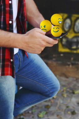 Man using phone sending emojis clipart