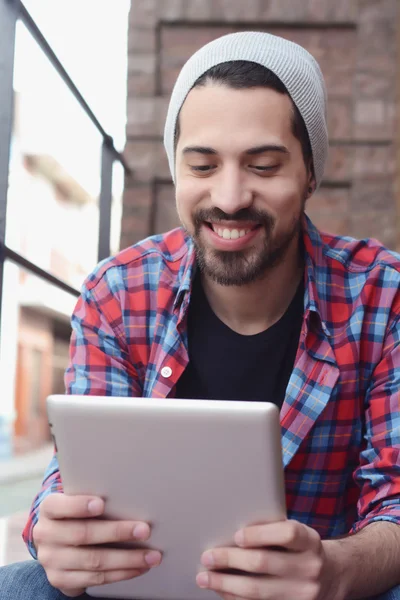 Latin man using a tablet. — Stock Photo, Image