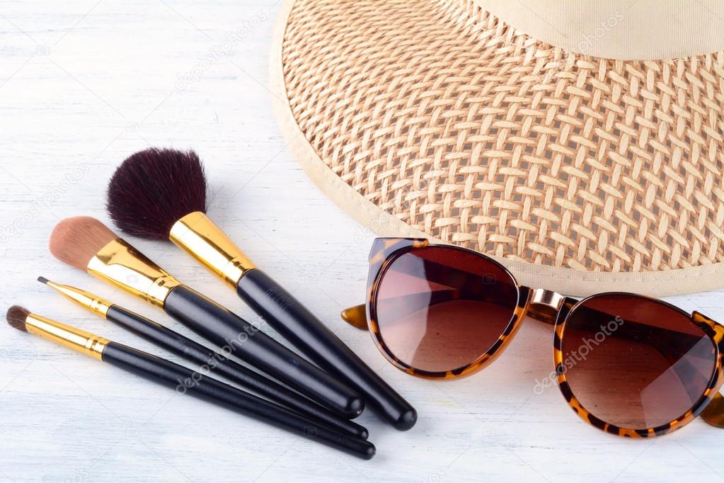 Sunglasses with make up brushes and a hat.