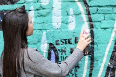 Kadın sokak duvara grafiti sprey boya ile çizim.