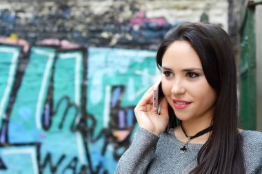 Genç bir kadın cep telefonuyla konuşuyor..