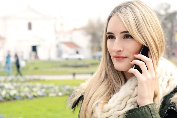 Porträtt av en ung kvinna som pratar i telefon. — Stockfoto