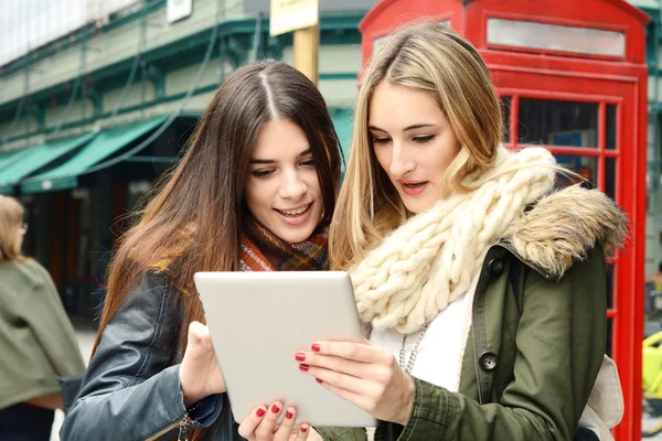 Zwei junge Freundinnen auf einer gemeinsamen Reise und mit dem Tablet. — Stockfoto