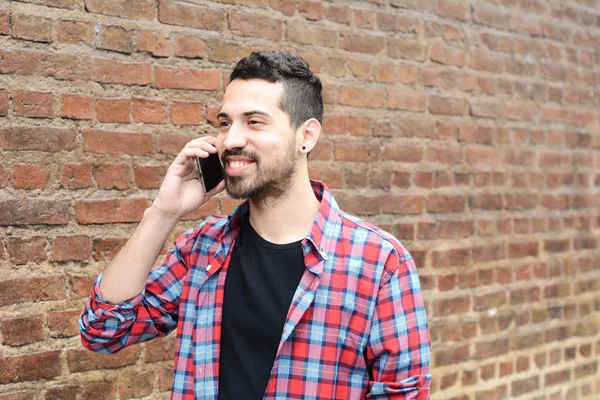 Молодой латинос разговаривает по телефону . — стоковое фото