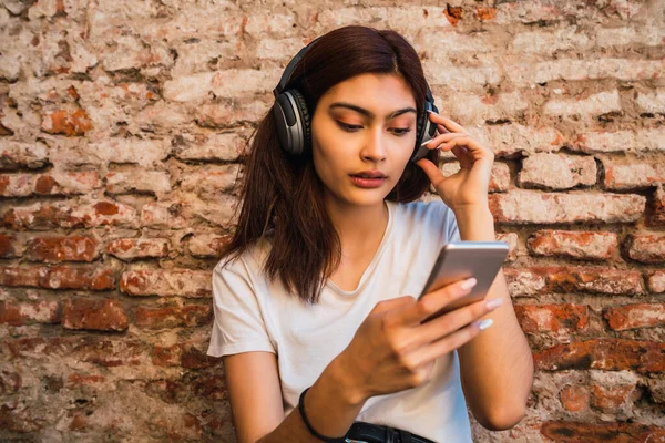 Gyönyörű Fiatal Zenét Hallgat Használja Okostelefonját Téglafal Ellen Technológiai Koncepció — Stock Fotó