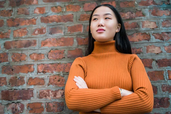 벽돌 벽에 맞서 싸우는 아시아 여자. — 스톡 사진