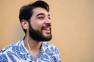 Genç adam kulaklıkla müzik dinliyor..