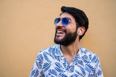 Genç adam kulaklıkla müzik dinliyor..