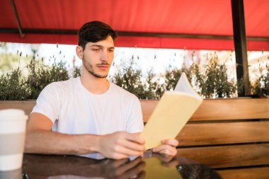 Boş zamanın tadını çıkaran ve kitap okuyan bir adam..