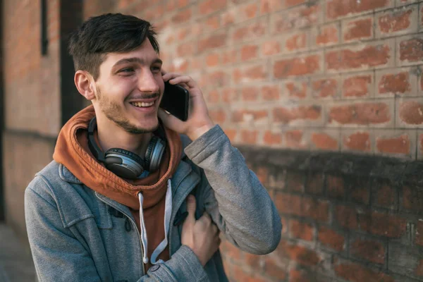 Jongeman in gesprek aan de telefoon buiten. — Stockfoto