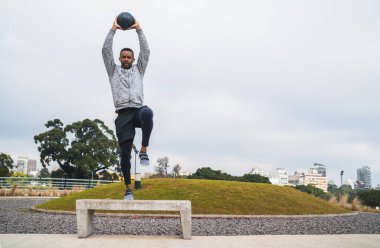 İlaç topuyla atletik adam eğitimi.