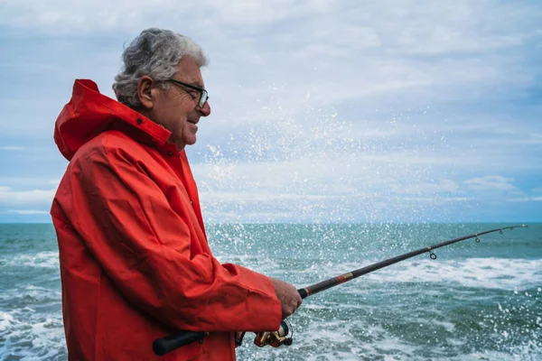 Vieil homme pêchant dans la mer. — Photo