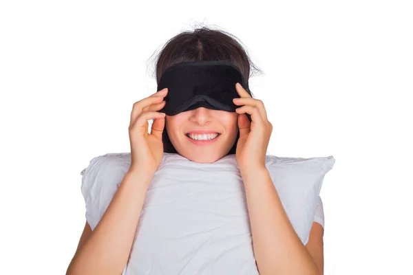 Žena v masce spánku a drží polštář. — Stock fotografie