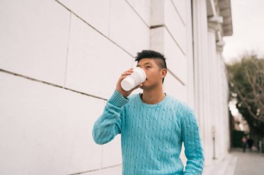 Asyalı bir adam bir fincan kahve içiyor..