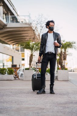 Dışarıda yürürken bavul taşıyan bir turist..