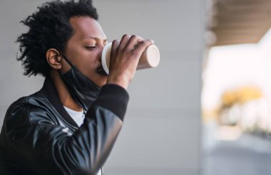 Afro adam dışarıda bir fincan kahve içiyor..