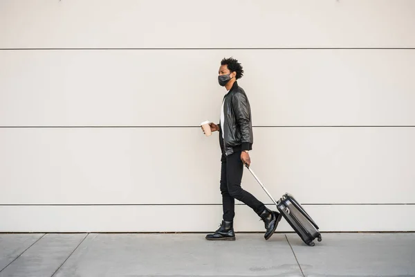 Uomo turistico che trasporta valigia mentre cammina all'aperto. — Foto Stock