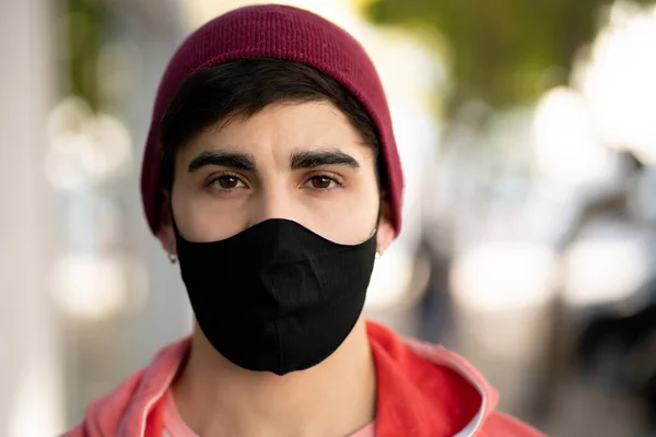 Joven hombre usando mascarilla al aire libre. — Foto de Stock