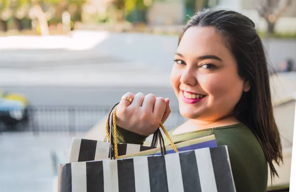 Mujer joven sosteniendo bolsas de compras en el centro comercial. — Foto de Stock