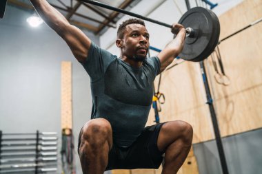 Crossfit sporcu halterle egzersiz yapıyor..