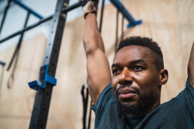 Sporcu adam spor salonunda egzersiz yapıyor..