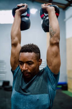 Atletik adam Crossfit kettlebel ile egzersiz yapıyor..