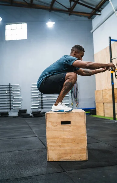 Uomo atletico che fa esercizio di salto scatola. — Foto Stock
