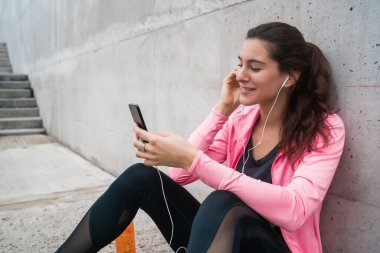 Atletik kadın telefonunu kullanıyor..