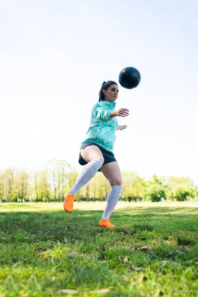 Ung kvinne som øver på fotball med ball. – stockfoto