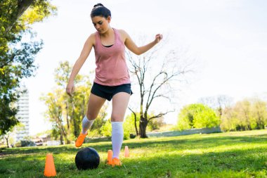 Genç bayan futbolcu sahada pratik yapıyor..