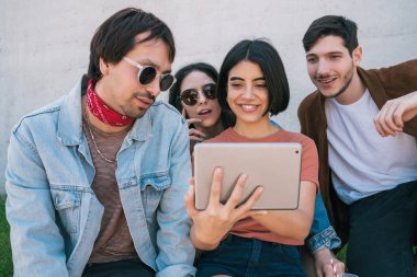 Açık havada dijital tablet kullanan arkadaşlar.