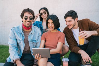 Açık havada dijital tablet kullanan arkadaşlar.