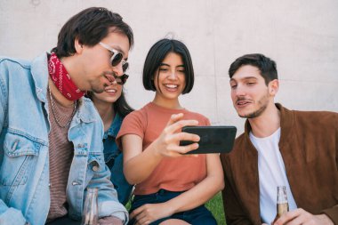 Bir grup arkadaş telefonla selfie çekiyor..