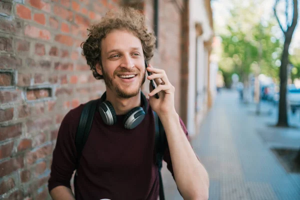 Jongeman in gesprek aan de telefoon buiten. — Stockfoto