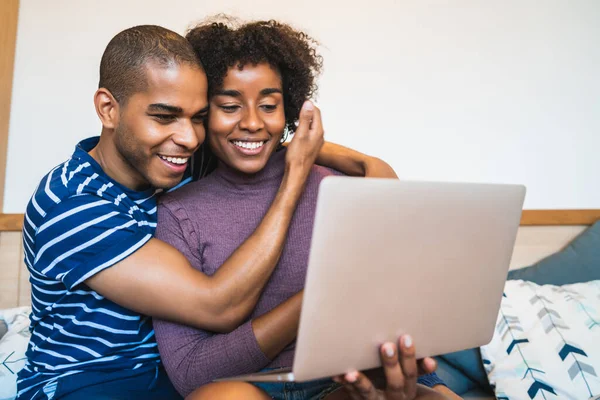 Young couple using laptop on couch at home. — Stock Photo, Image