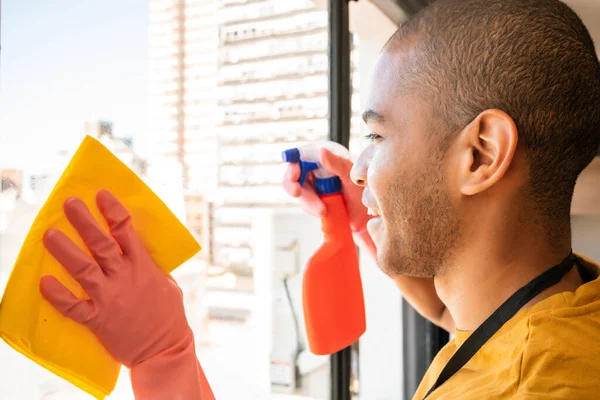 Männliche Haushälterin putzt Glasfenster zu Hause. — Stockfoto