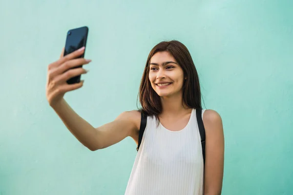 Νεαρή γυναίκα που παίρνει selfies με τηλέφωνο. — Φωτογραφία Αρχείου