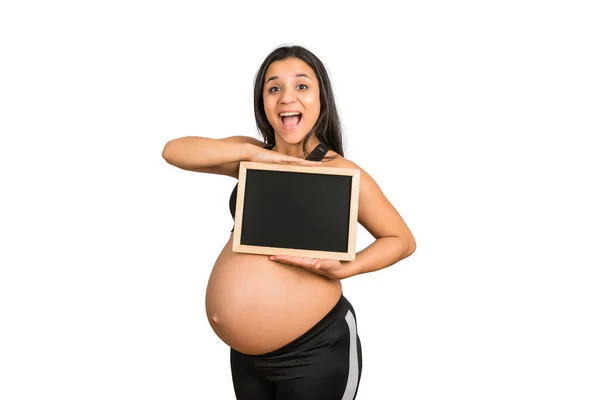 Kobieta w ciąży pokazuje coś na tablicy.. — Zdjęcie stockowe