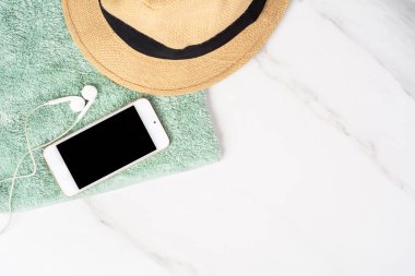 Akıllı telefon, şapka, güneş kremi ve havlu..