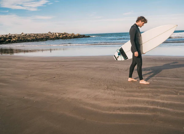 Surfer steht mit seinem Surfbrett im Meer. — Stockfoto