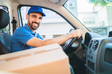 Karton kutularla dolu bir minibüs taşıyan teslimatçı..