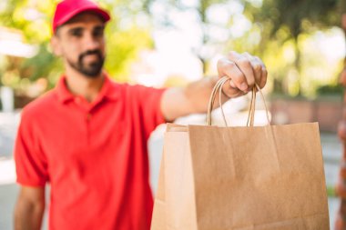 Eve teslimat yaparken paket taşıyan teslimatçı..