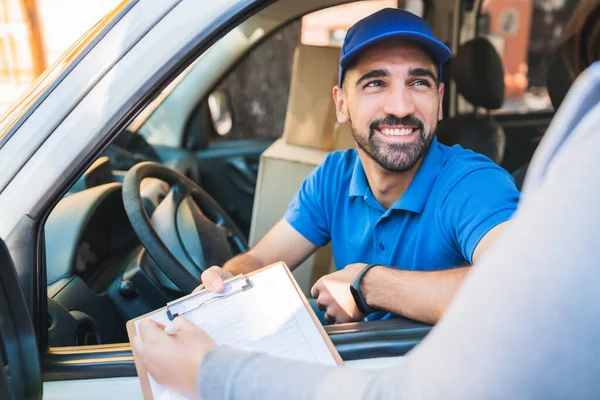 Repartidor en furgoneta mientras el cliente firma en portapapeles. — Foto de Stock