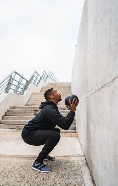 Uomo atletico che fa esercizio di palla da parete. — Foto Stock