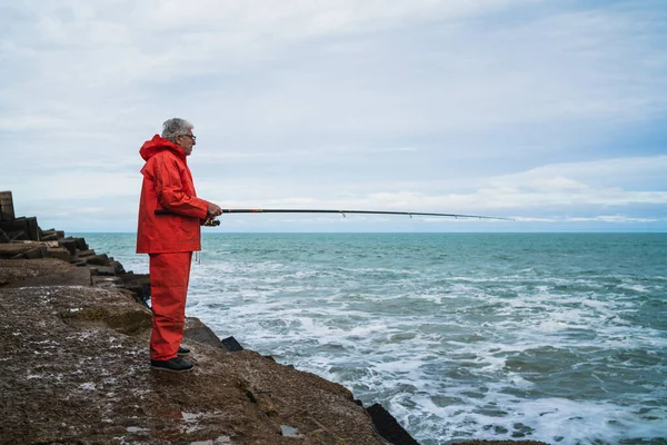 Vieil homme pêchant dans la mer. — Photo