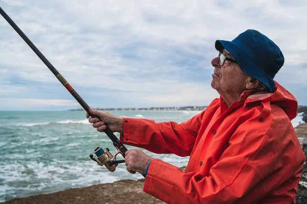 Starší muž rybaří v moři. — Stock fotografie