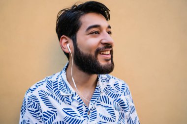 Genç adam kulaklıkla müzik dinliyor..